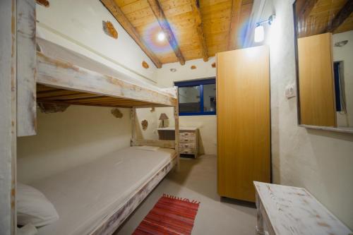 a bedroom with two bunk beds and a window at Apágkio Filoxenia in Archangelos