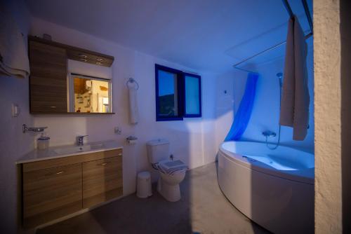 a bathroom with a tub and a toilet and a sink at Apágkio Filoxenia in Archangelos