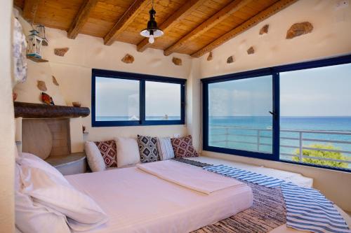 a bedroom with a bed and a large window at Apágkio Filoxenia in Archangelos