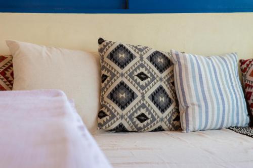 a group of pillows sitting on top of a bed at Apágkio Filoxenia in Archangelos
