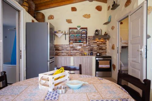 a kitchen with a table and a refrigerator at Apágkio Filoxenia in Archangelos