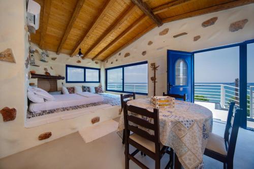a bedroom with a bed and a table and windows at Apágkio Filoxenia in Archangelos