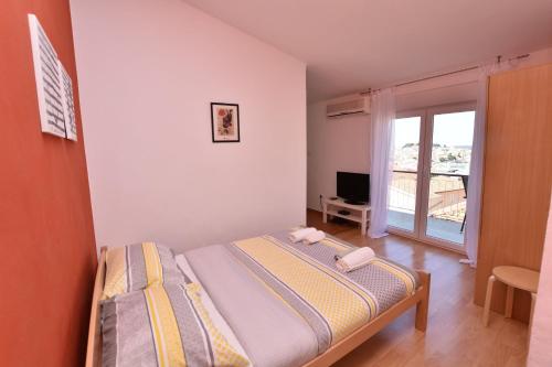- une petite chambre avec un lit et une fenêtre dans l'établissement Apartments Pasko, à Primošten