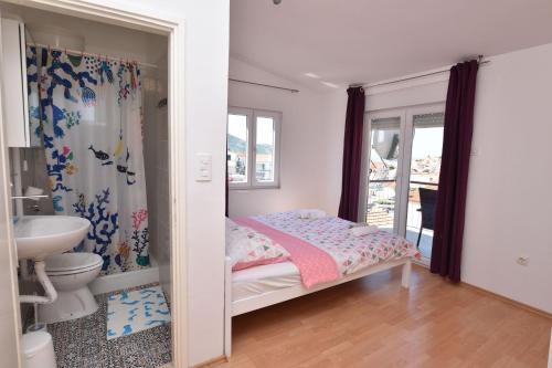 - une petite chambre avec un lit et une salle de bains dans l'établissement Apartments Pasko, à Primošten