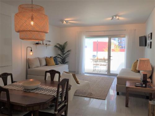 ein Wohnzimmer mit einem Tisch und einem Sofa in der Unterkunft Alto Mar Apartment in Peniche