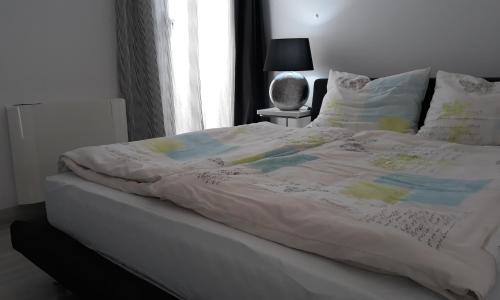 a bed with a white comforter on top of it at St.Barth Apartments in Šibenik