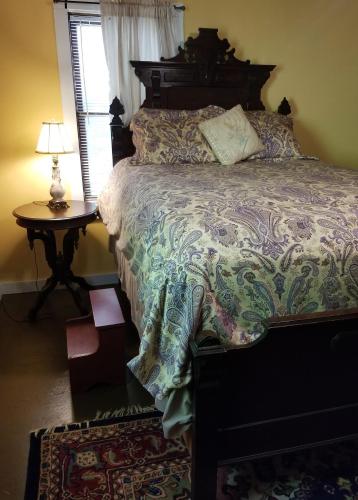 a bedroom with a bed and a table with a lamp at The Cabins at Healing Springs in Crumpler