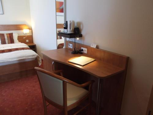 a hotel room with a desk and a bed at Boutique Hotel Wolfsburg in Wolfsburg