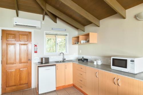 a kitchen with a sink and a microwave at Moana Sands Beachfront Hotel in Rarotonga