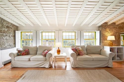 a living room with two couches and a table at Eido Da Portela - Casa De Campo in Carregadouro