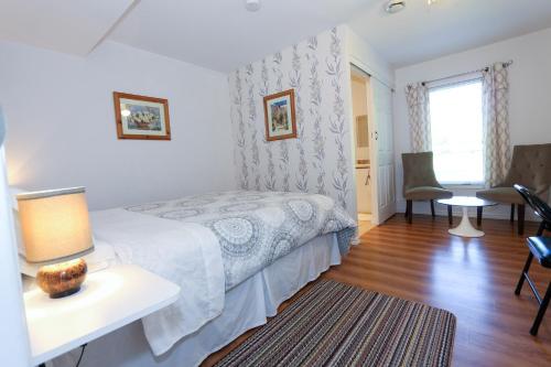 a bedroom with a bed and a table with a lamp at Cedar Drive Inn in Crysler