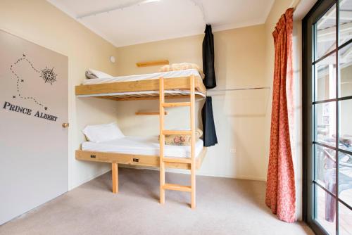 a bunk bed in a room with a window at The Prince Albert Backpackers & Bar in Nelson