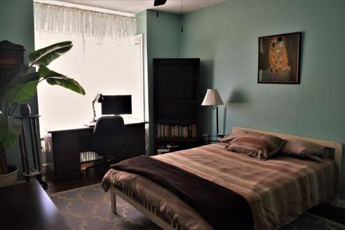 a bedroom with a bed and a desk and a window at Private Rooms, Shared Bath in a Private Home Minutes From Logan Airport in Boston