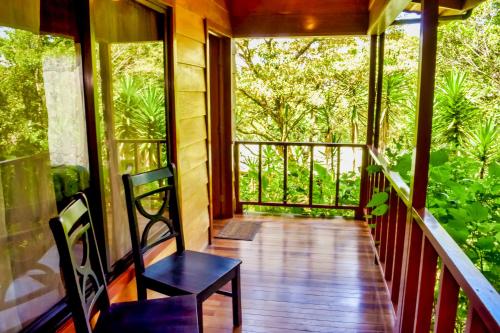 a room with a balcony with a view of trees at Jaguarundi Jungle Lodge - Monteverde in Monteverde Costa Rica