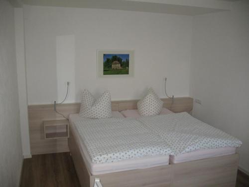 a bedroom with a bed and a picture on the wall at Pension Hinz & Kunz in Weimar
