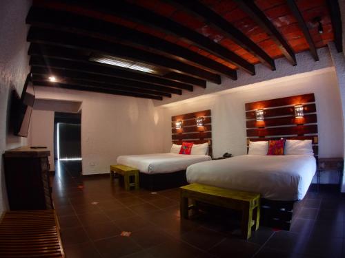 a room with two beds and a fireplace in it at Las Rocas Resort & Spa in Rosarito
