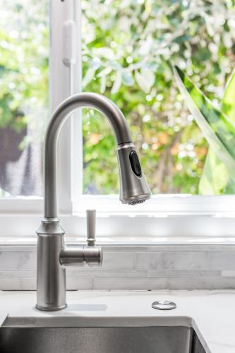 a kitchen sink with a faucet in front of a window at Charming 1-Bedroom Home near Downtown Culver in Los Angeles