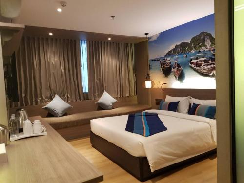 Pokój hotelowy z dużym łóżkiem i kanapą w obiekcie Bizotel Premier Hotel & Residence w mieście Bangkok