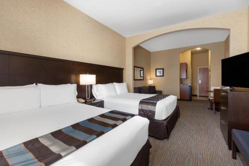 a hotel room with two beds and a flat screen tv at Wingate by Wyndham Moses Lake in Moses Lake