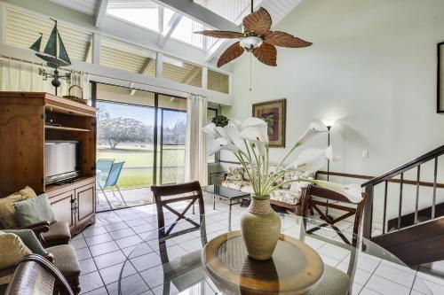 een woonkamer met een vaas met bloemen op een tafel bij Pupukea Condo in Kahuku