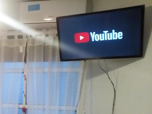 a television with a youtube sign on a wall at Oroño 1 in Rosario