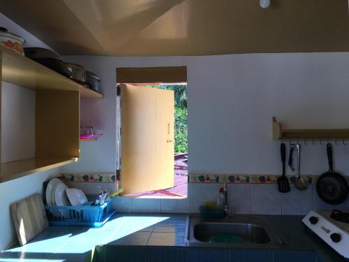 a kitchen with a sink and a open window at Reynaldo's Upstairs in Puerto Galera
