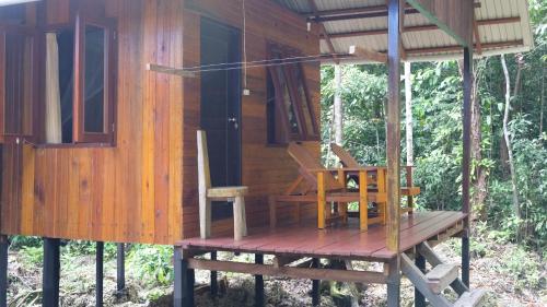 a cabin with a table and chairs on a deck at Maratua Guesthouse in Maratua Atoll