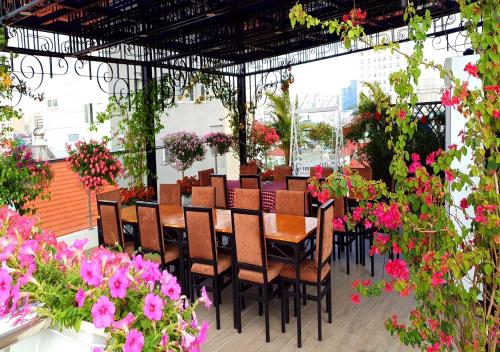 a restaurant with a table and chairs and flowers at Newsky Serviced Apartment in Hanoi