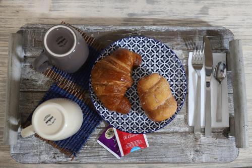 a tray with a plate of bread and a cup of coffee at b&b Pirriera in Bagheria