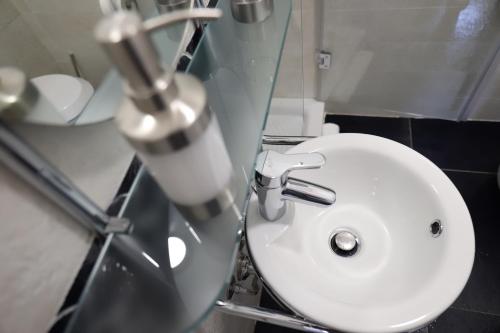 a white sink in a bathroom with a mirror at b&b Pirriera in Bagheria