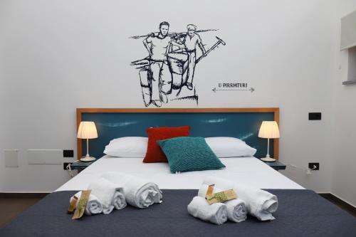a bedroom with a large bed with towels on it at b&b Pirriera in Bagheria