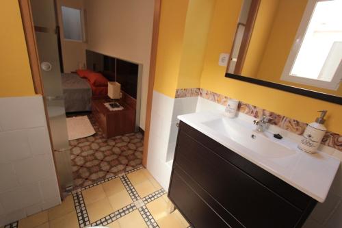 ein Bad mit einem Waschbecken und einem Spiegel sowie ein Schlafzimmer in der Unterkunft Can Clos Bonet in Amposta
