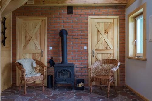 a brick wall with two chairs and a stove at KTA TARPAN Mały Domek in Masiewo