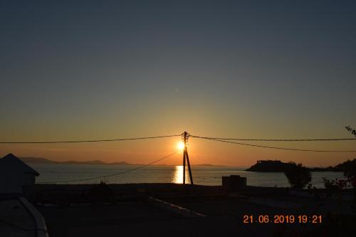 a sunset over the water with a street light at Infinity Apartments in Naxos Chora