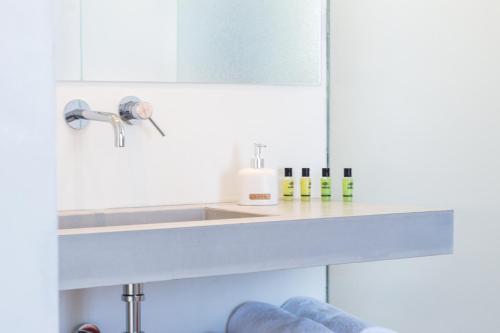 a bathroom with a sink and a mirror at Wabi Luxury Suites & Maisonettes Ios in Ios Chora