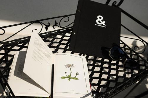 a table with two books and a laptop on it at Hotel Florian&Godler in Karlovac