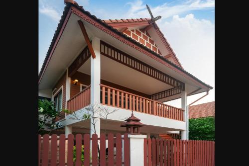 a house with a red fence in front of it at Naiyang Beach Private Pool Villa in Nai Yang Beach