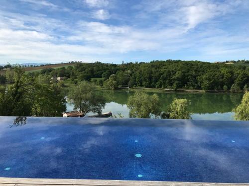 a large swimming pool with a view of a lake at Résidence L'Oustal Del Carlat in Carla-Bayle