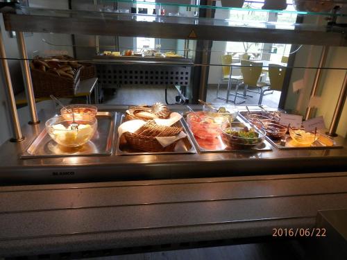 a buffet line with different foods on trays at Jugendherberge Westerland in Westerland (Sylt)