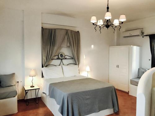 1 dormitorio con cama y lámpara de araña en Sarakiniko View Studios, en Mandrakia