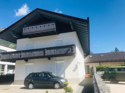 a car parked in front of a white house at Ferienhaus Butterfly in Garmisch-Partenkirchen