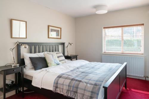 um quarto com uma cama grande e uma janela em Henley self catering House em Henley on Thames