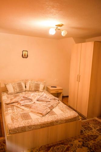 a bedroom with a bed and a cabinet at Pensiunea La Cernat in Şugag