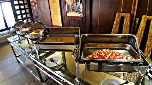 a buffet with several trays of food on a table at Panacea Suites Hotel in Borg El Arab