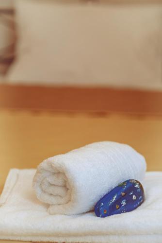 a stack of white towels with a blue tie at Matafia's House in Kalamitsi
