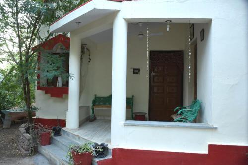 a house with a door and a bench on the porch at Sharad Baug homestay in Bhuj