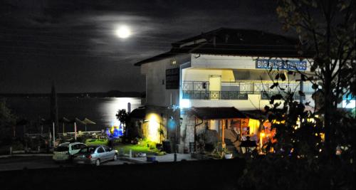 a building with cars parked in a parking lot at night at Big Blue Studios in Kallithea Halkidikis