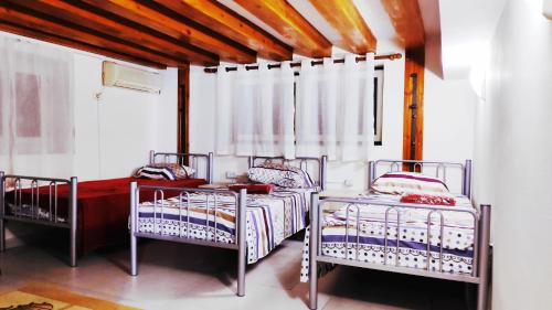 una camera da letto con due letti e una finestra di Tufina Hostel a Tirana