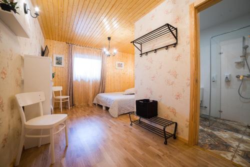 a bedroom with a bed and a table and a chair at Saules viesību nams in Birzgale
