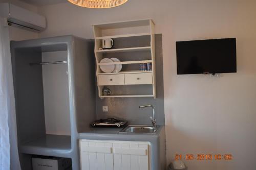 a small kitchen with a sink and a tv at Infinity Apartments in Naxos Chora